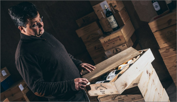 Image d'un homme qui ouvre une caisse de bouteilles de vin